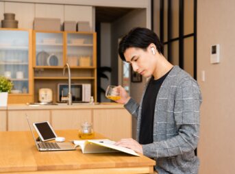 紅茶を飲みながら自宅で勉強する男性