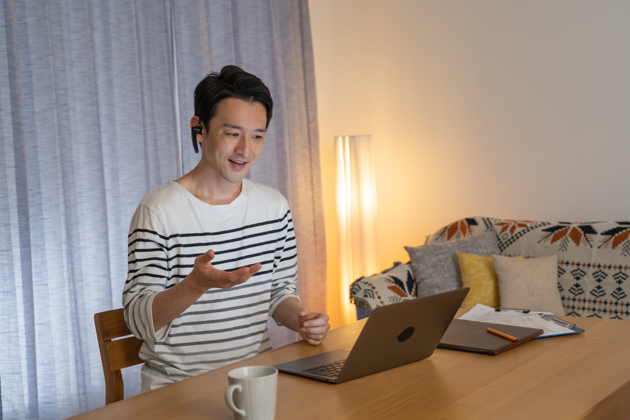 自宅のリビングでオンライン英会話のレッスンを受ける中年男性