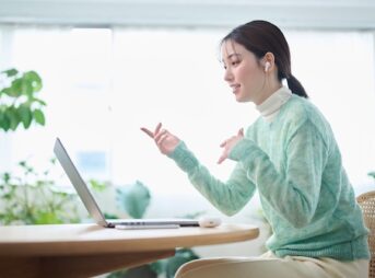 オンライン英会話を受ける緑色の服を着た女性