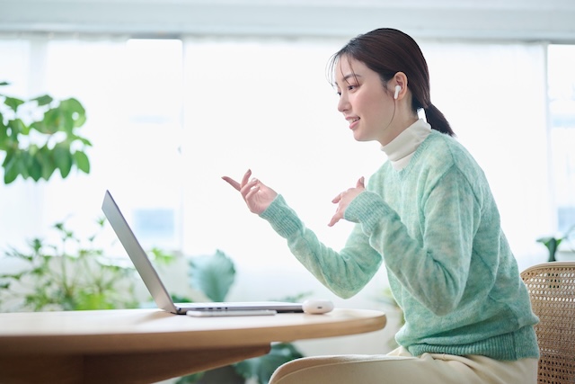 オンライン英会話を受ける緑色の服を着た女性