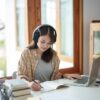 自宅でヘッドホンを付けて勉強する女性