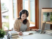 自宅でヘッドホンを付けて勉強する女性