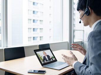 オンライン英会話のレッスンを受けるスーツの若い男性