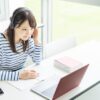 教室でオンライン英会話のレッスンを受ける私服の若い女性
