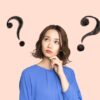 はてなマークが浮かぶ青い服を着た日本人女性