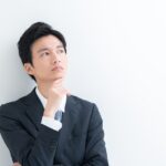 考えている様子のスーツを着た男性