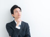 考えている様子のスーツを着た男性