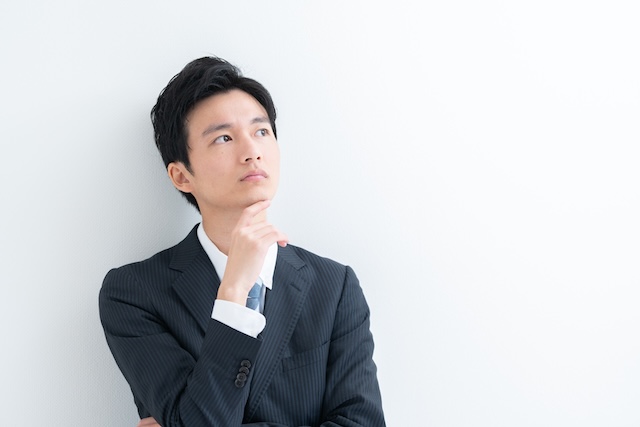 考えている様子のスーツを着た男性