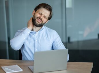 ノートパソコンの操作で肩が凝る男性