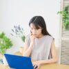 ノートパソコンを見ている緊張している様子の若い日本人女性