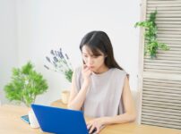 ノートパソコンを見ている緊張している様子の若い日本人女性