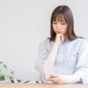 スマートフォンを見て不安そうな若い女性