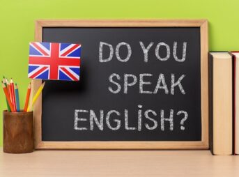 黒板に書かれたあなたは英語を話せますかの文字とイギリス国旗