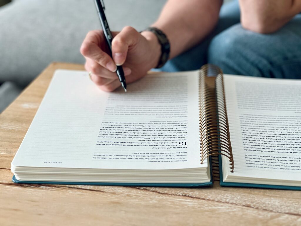 開いた参考書に書き込みながら勉強している様子